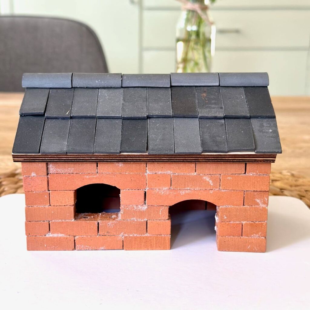 Gemauertes Ziegelhaus aus dem Steinbaukasten für Kinder mit anthrazitfarbenem Dach