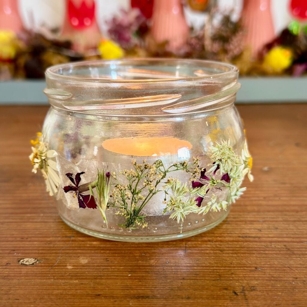 Windlicht aus Altglas mit Blüten und Gräsern basteln